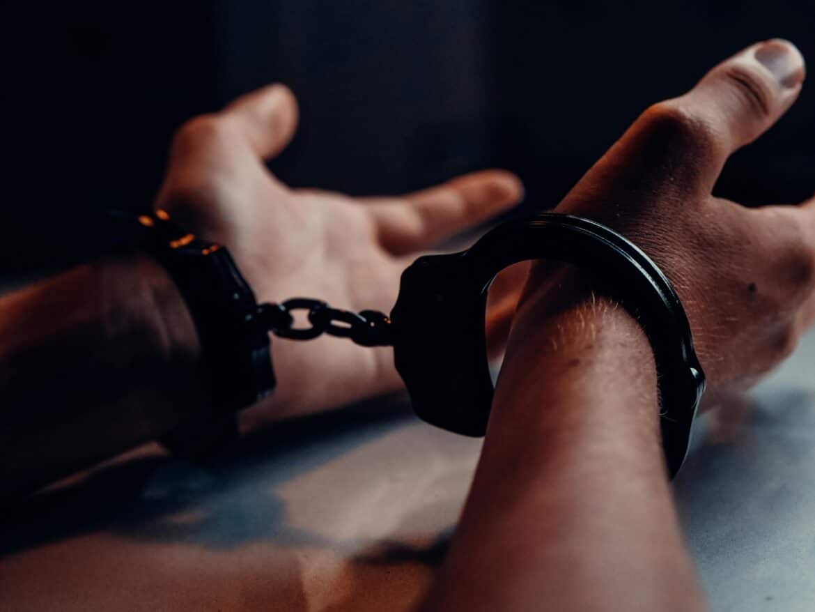 a-person-s-hands-on-the-table-wearing-handcuffs-stockpack-pexels A person s hands on the table wearing handcuffs