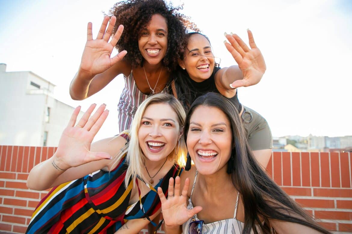 smiling-young-diverse-ladies-showing-hi-sign-while-taking-selfie-on-terrace-stockpack-pexels Smiling young diverse ladies showing hi sign while taking selfie on terrace