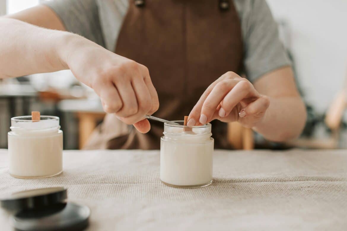 A close up shot of a person cutting the wick of a candle